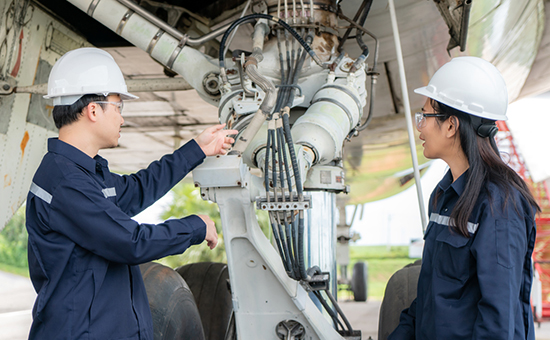 Asian man and woman engineer maintenance airplane team repairs, fixes, modernization and renovation in front airplane from  in airport.